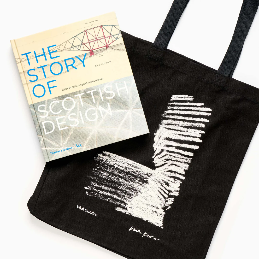 A black tote bag with a white design, a book titled 'The Story of Scottish Design' laying on top.