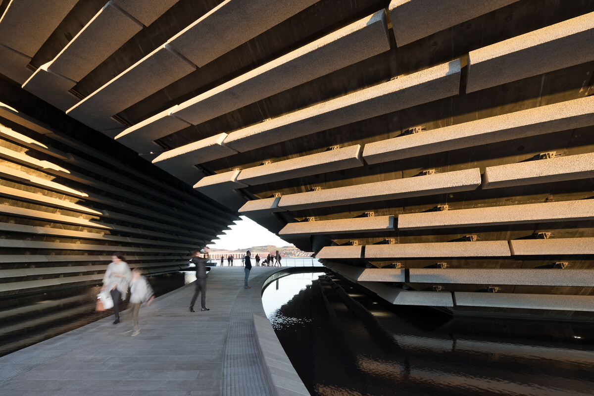 People walking under the archway in the middle of V&A Dundee