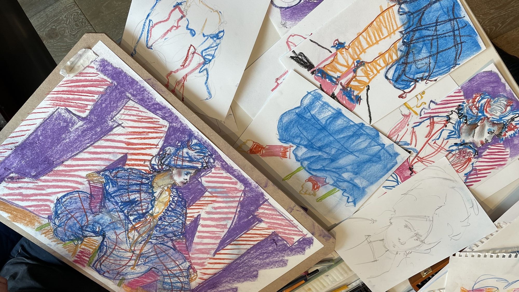 A collection of colourful fashion sketches and drawings featuring abstract figures in vibrant reds, blues, and purples, scattered on a surface.