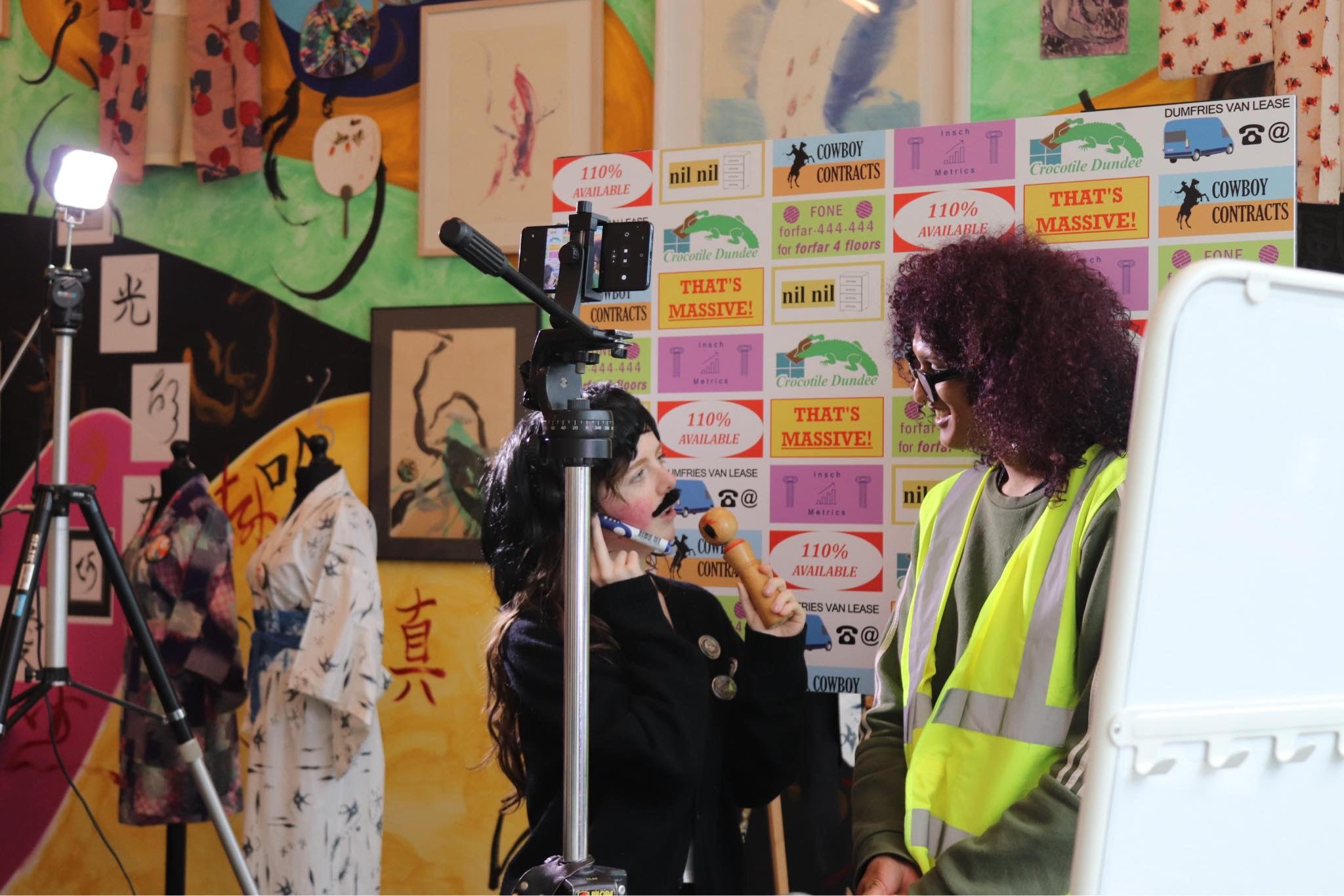 Two people performing in front of a camera