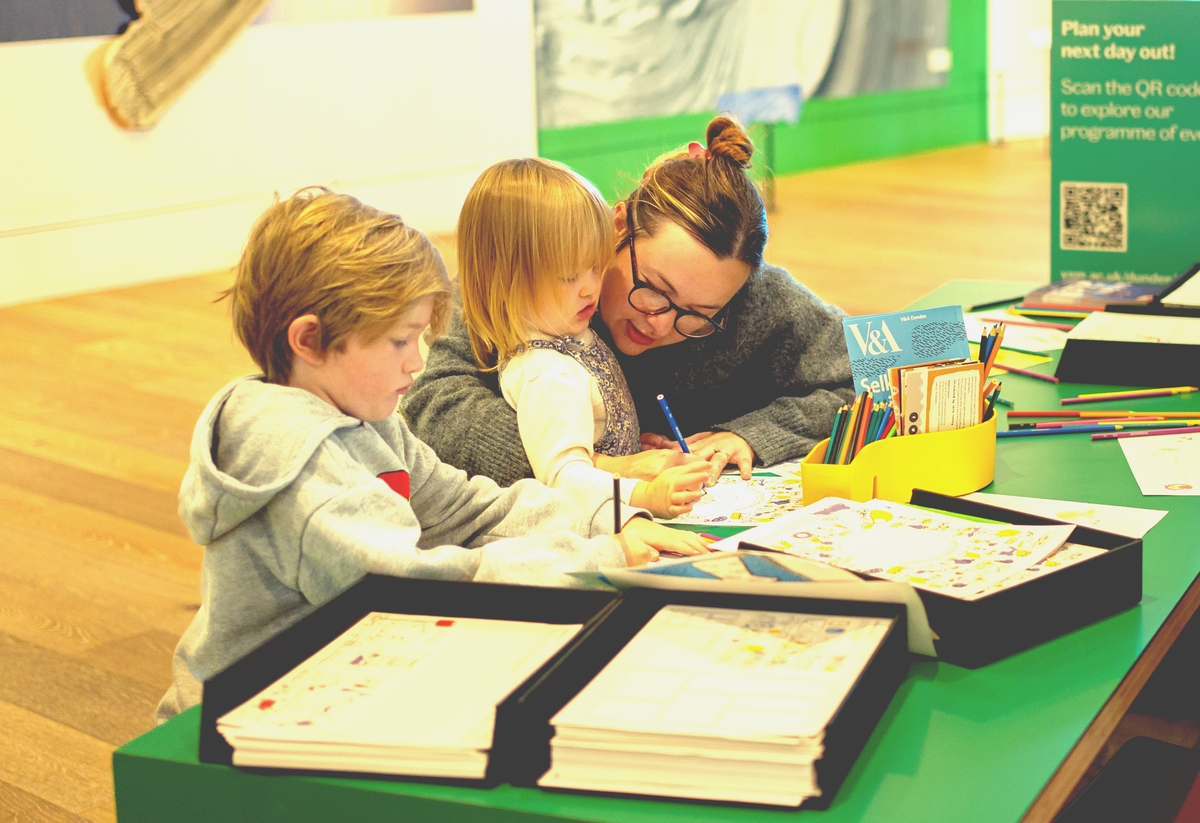 Two children doing a drawing activity with an adult