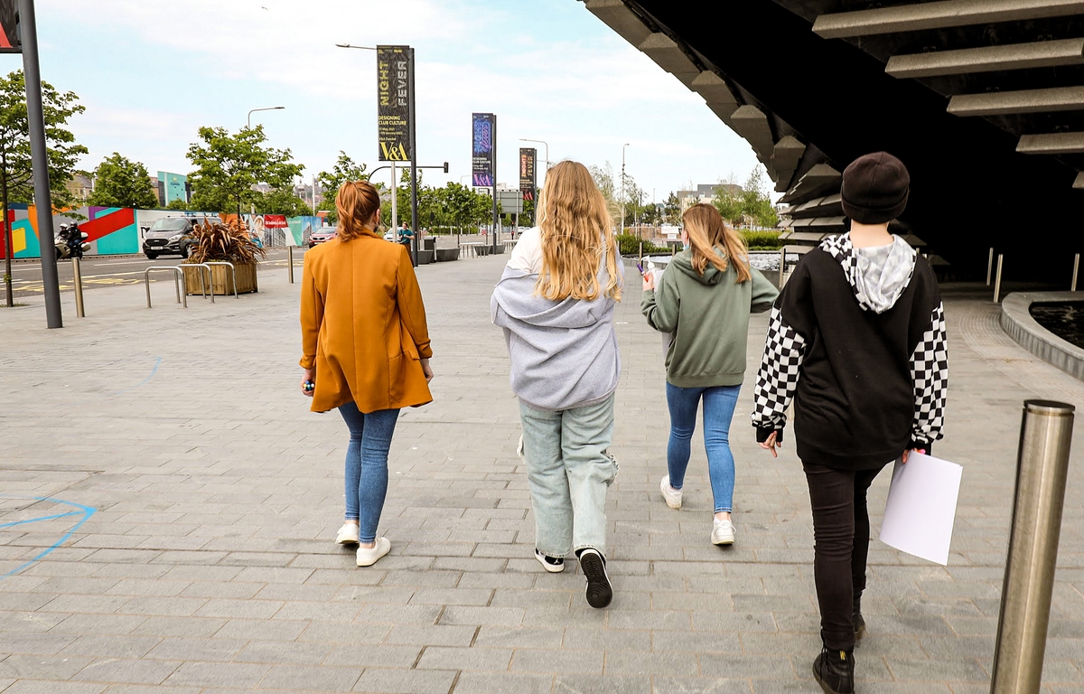 A group of people on a tour outside of V&A Dundee