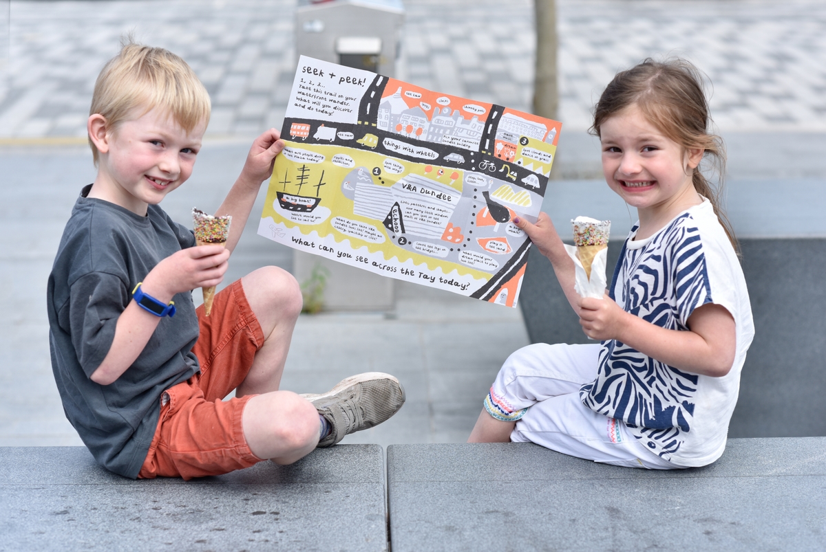 Two children holding a trail guide and ice cream cones