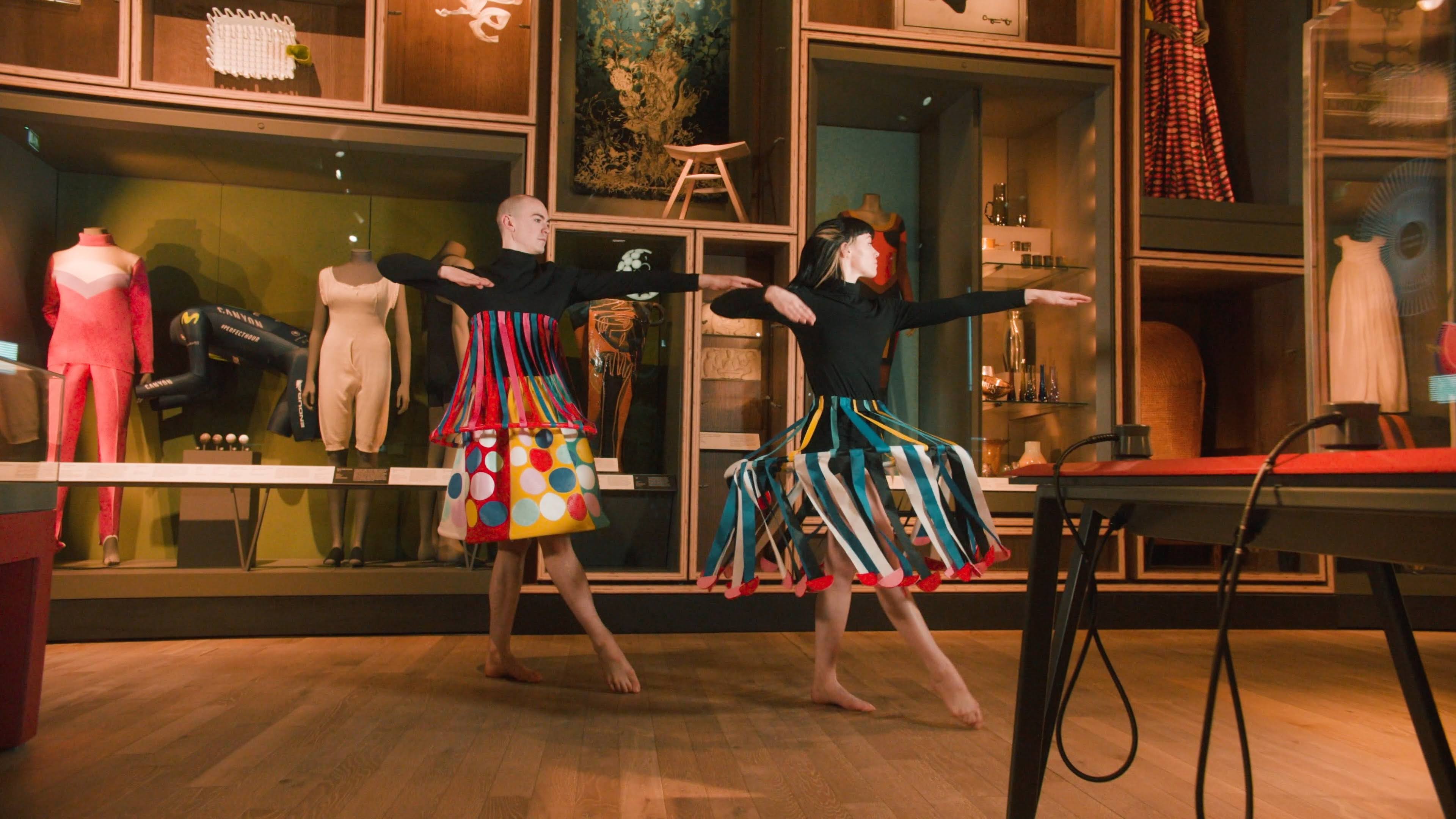 Two dancers in circus inspired outfitts dancing around the Scottish Design Galleries at V&A Dundee