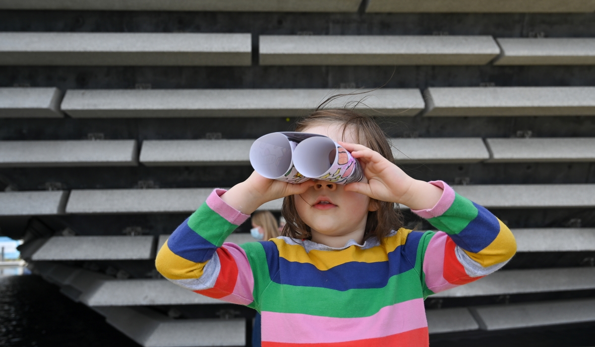 A little girl using some home-made binoculars at V&A Dundee