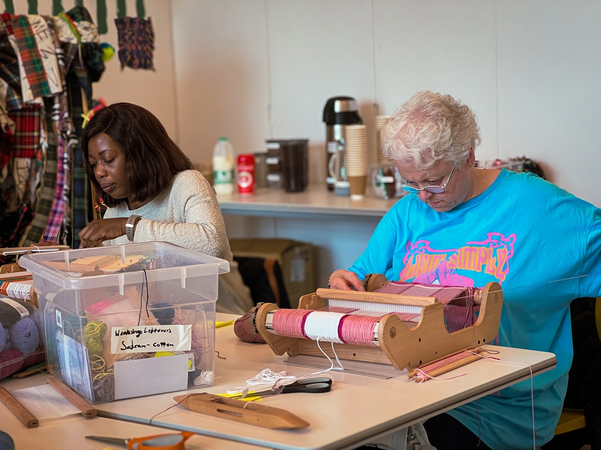Two female weavers operating a loom in the Learning Studios at V&A Dundee