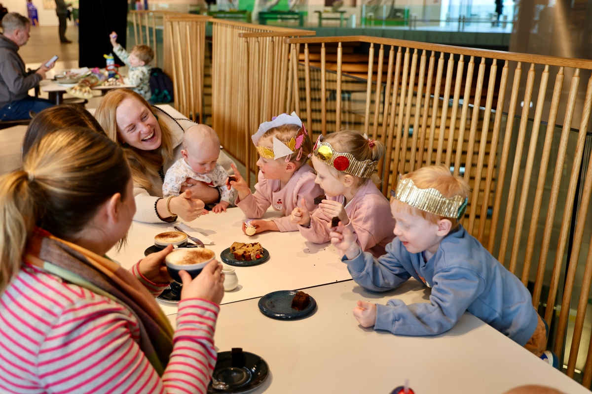A group of adults and children sitting at a table eating cake