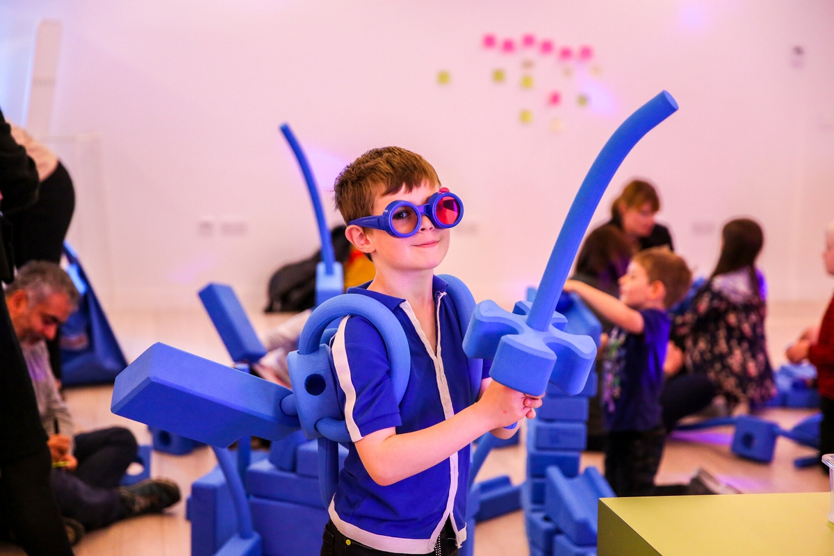 A child wearing blue glasses with foam toys.
