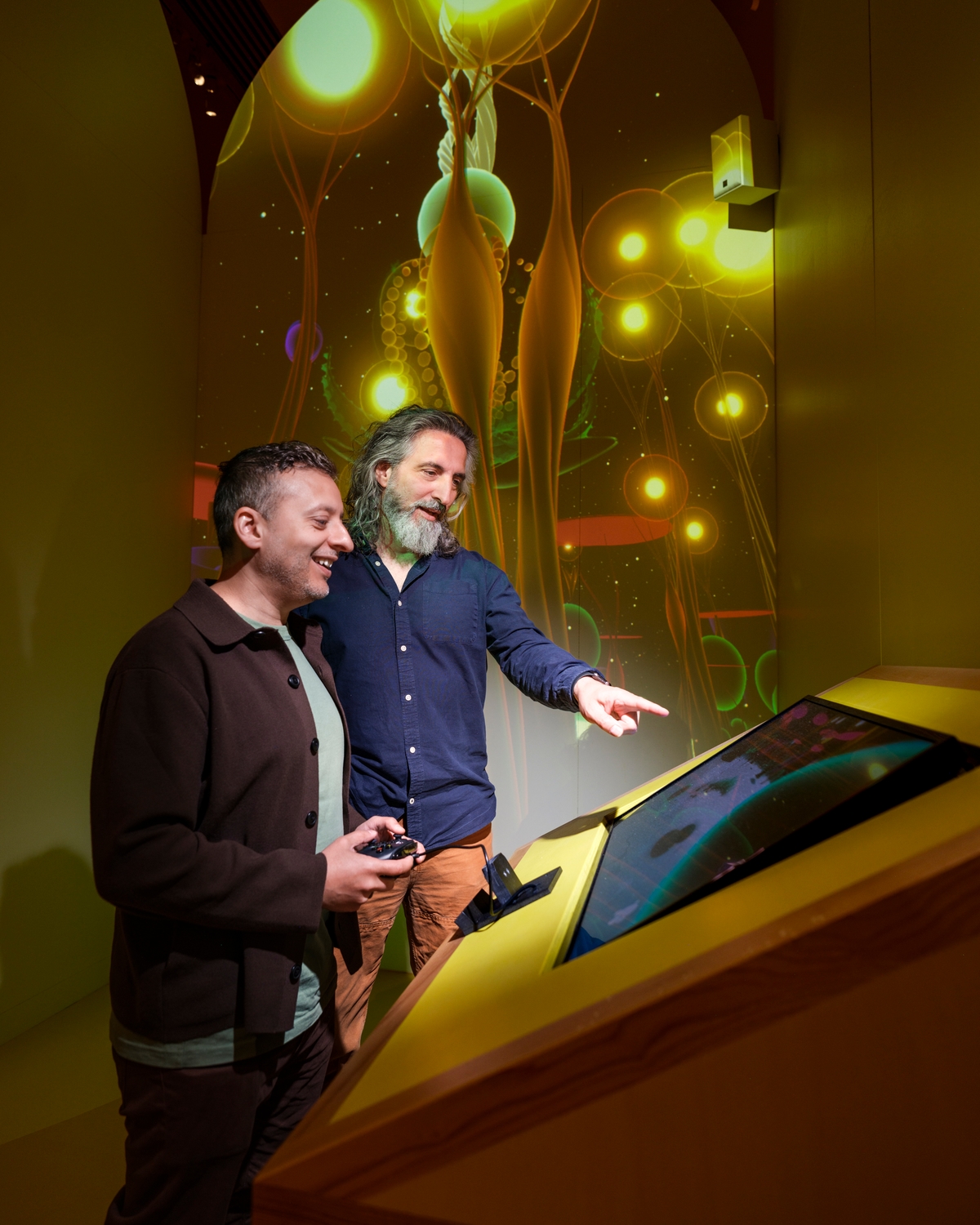 Two people standing playing a video game