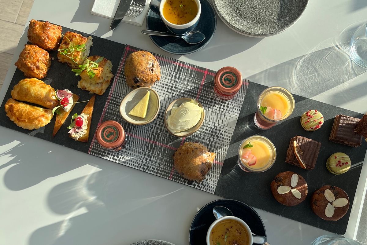 A table with a selection of cakes and pastries on a slate plate.