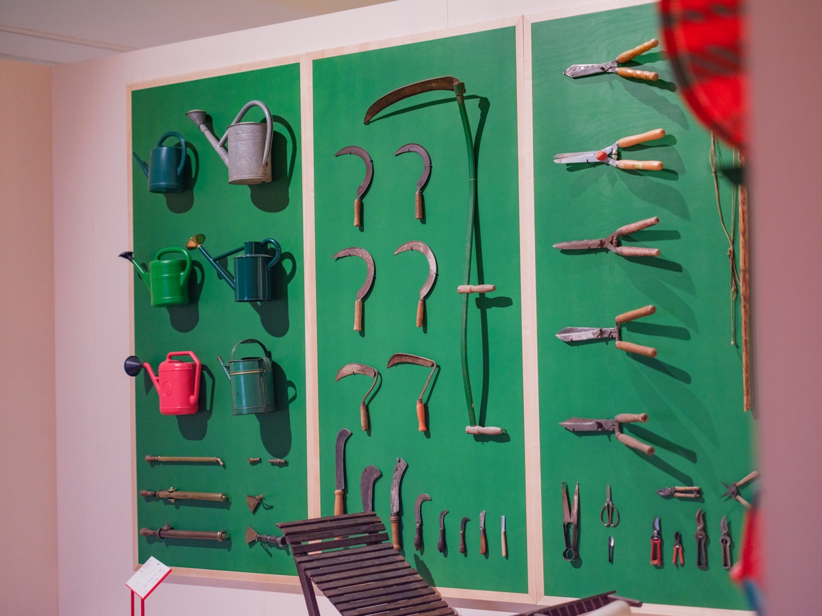 A wall of garden tools on a green background