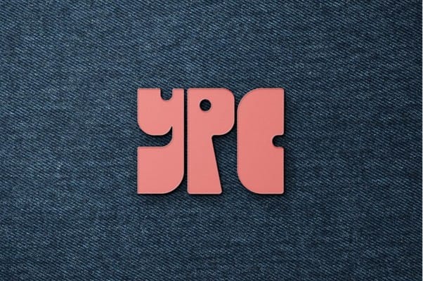 Red stylized letters "YPC" on a dark blue denim background.